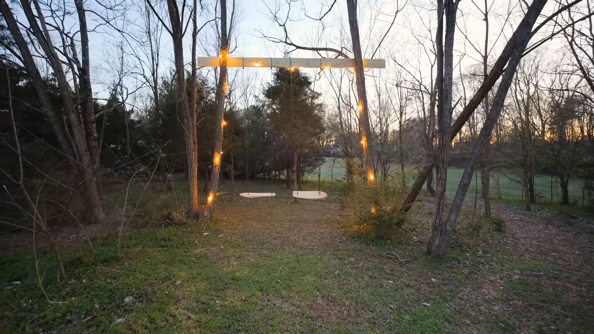 old-fashioned swing set with string lights out in the backyard