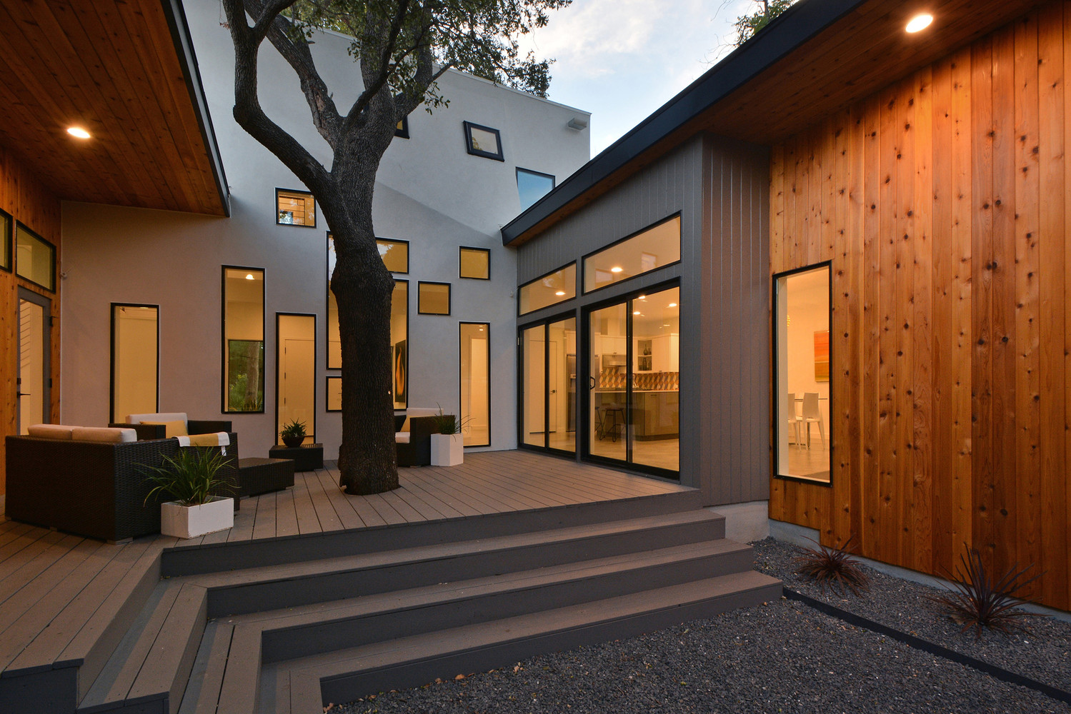 outside area of a modern house with dark colored sofas and a table