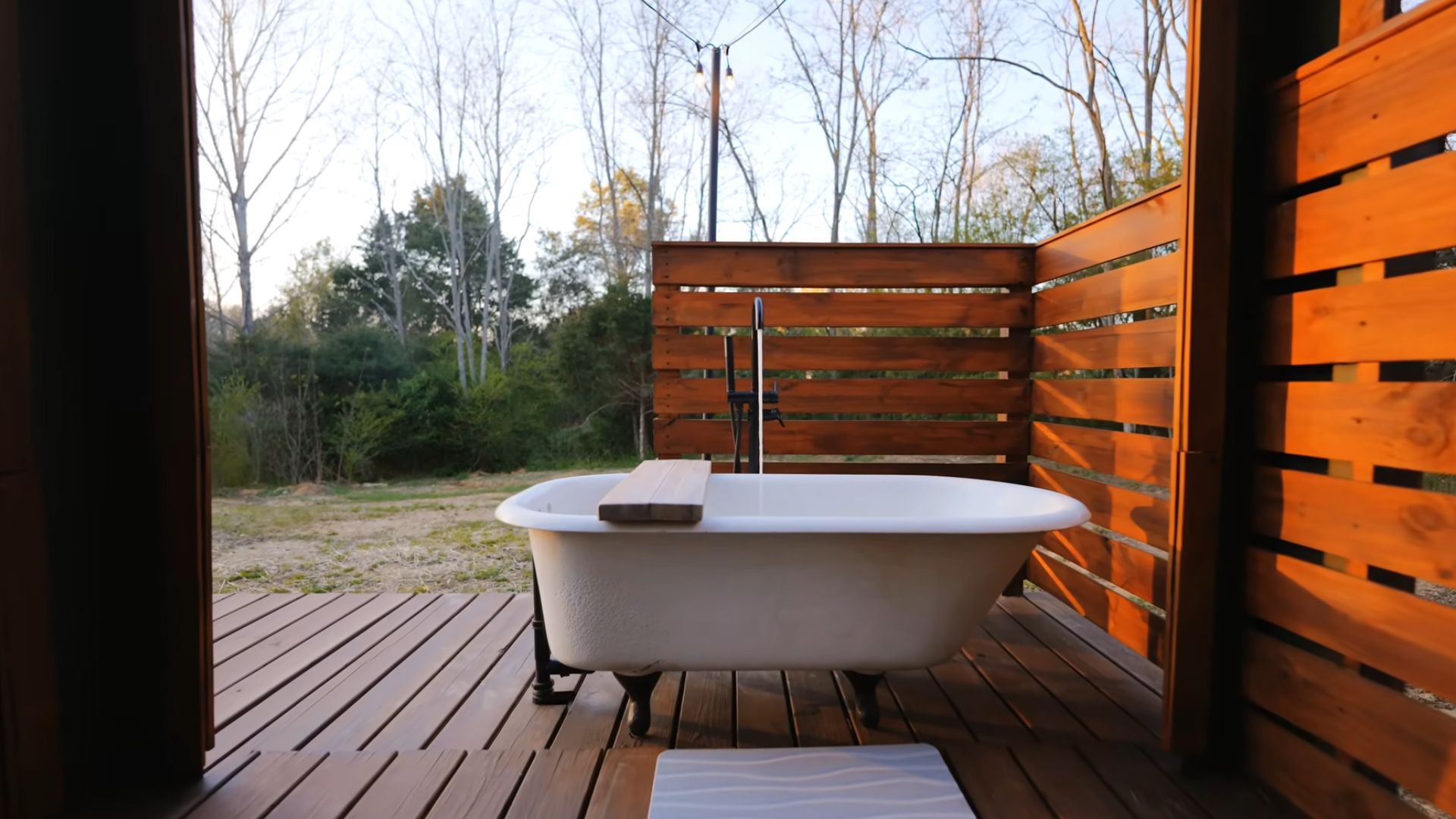 outside bath tub on the porch, privacy from the wooden planks around it