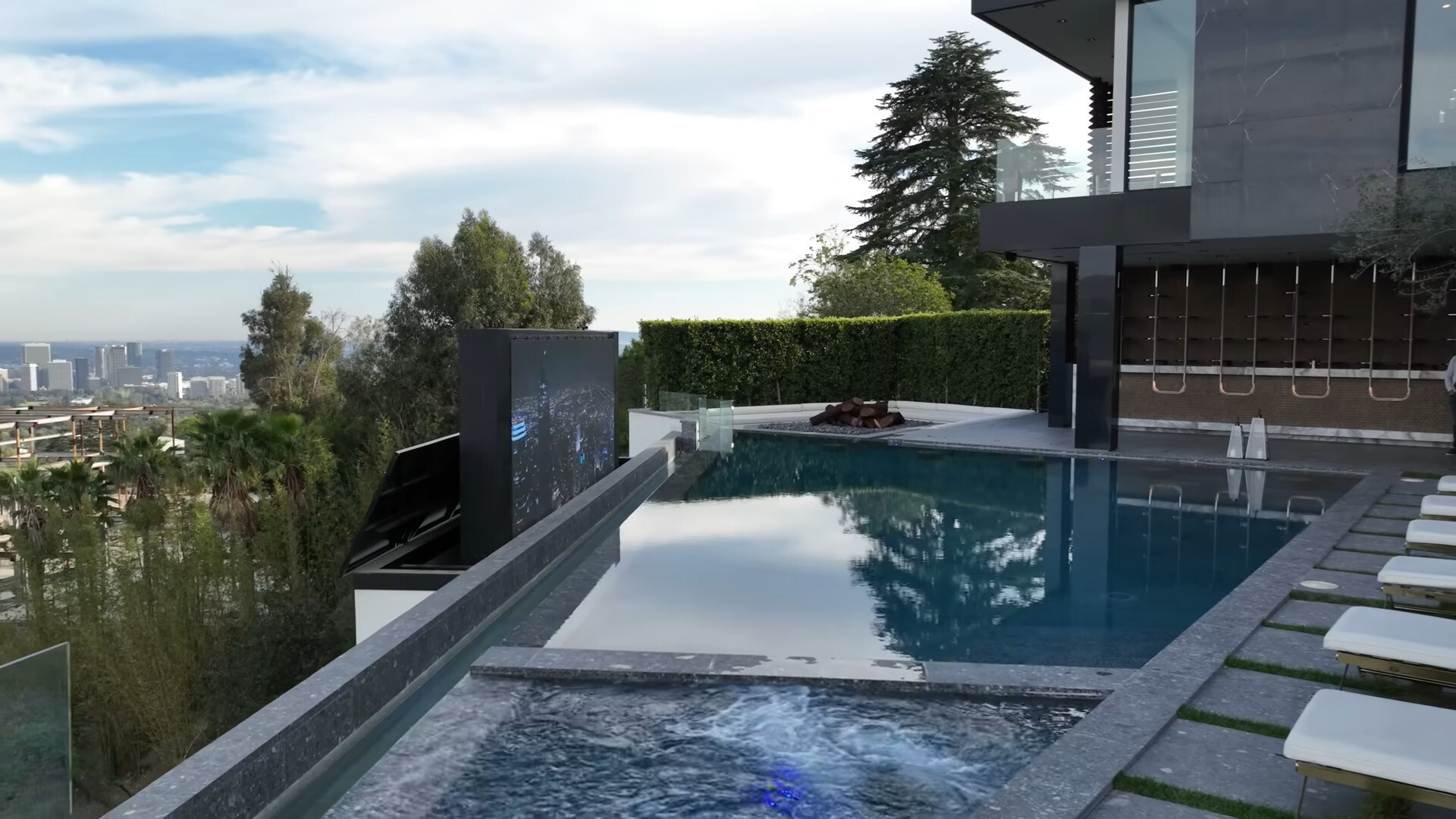 pool, deck chairs and a huge tv screen next to the pool