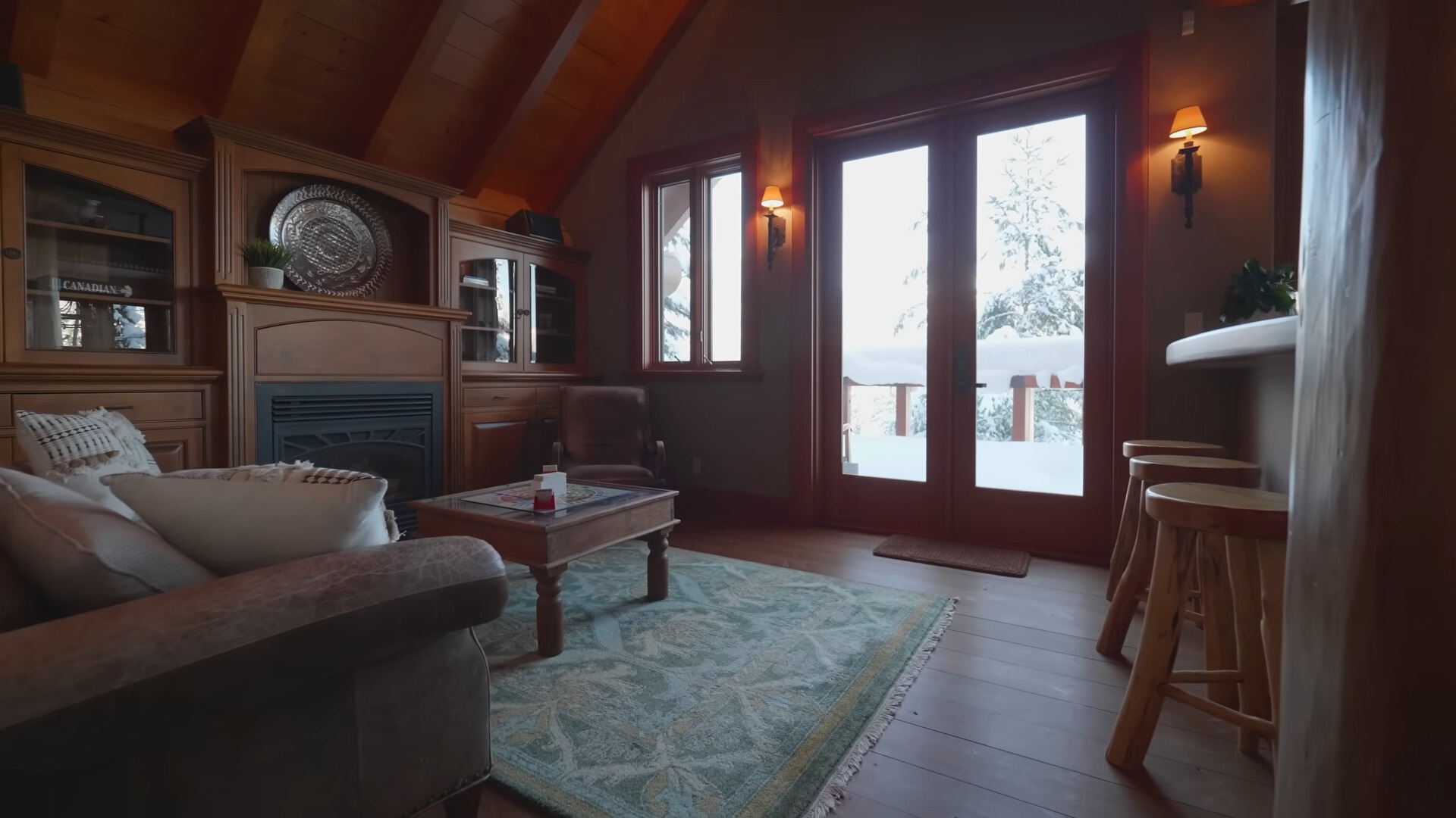 living room with brown walls, small brown table, fireplace, warm lightning, brown couch and chair