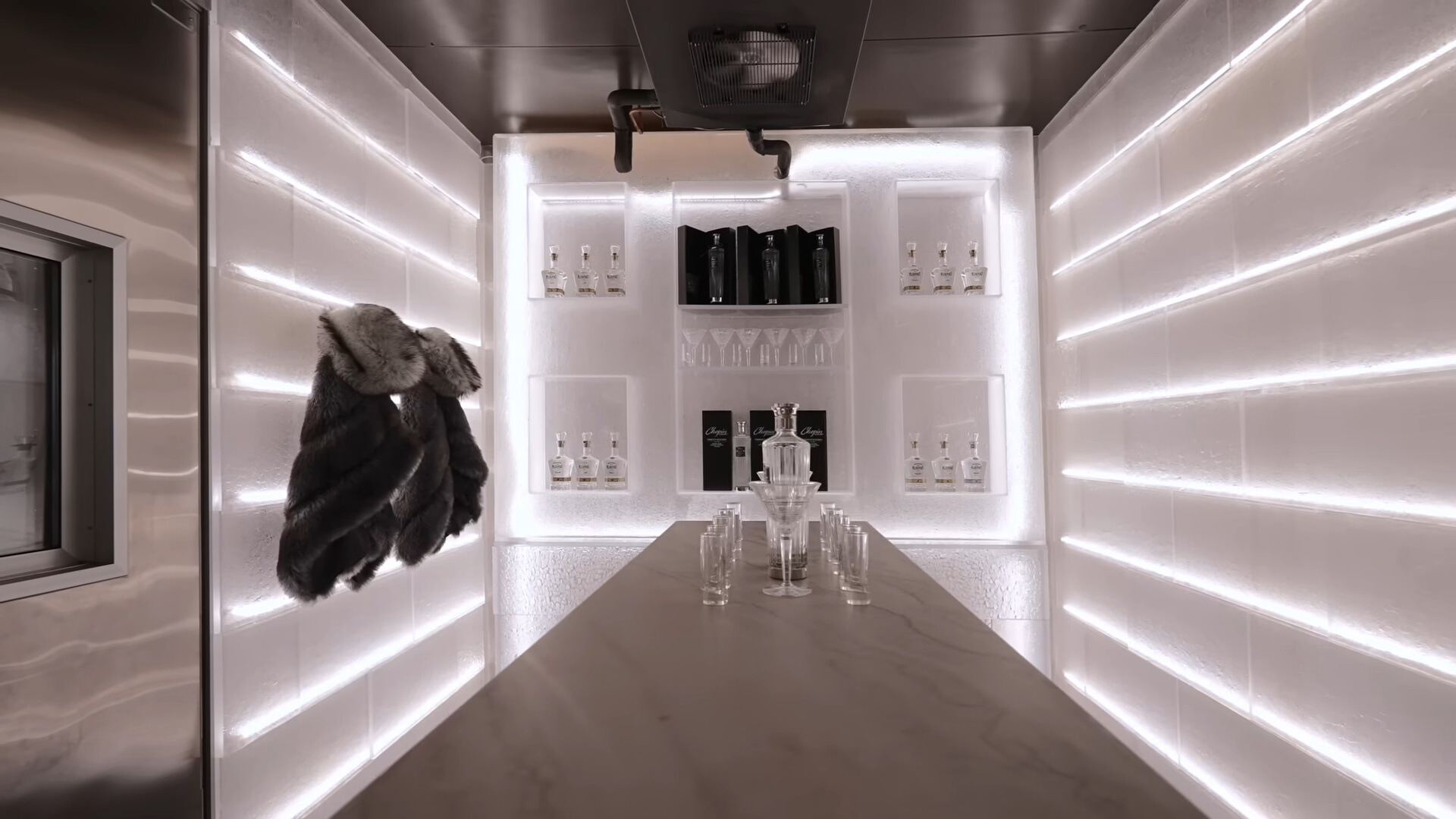 vodka cellar with white led lights, vodka bottles, glasses and jackets