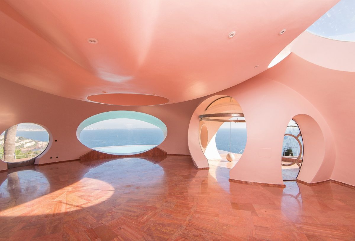 an empty room with round windows all around and light pink walls