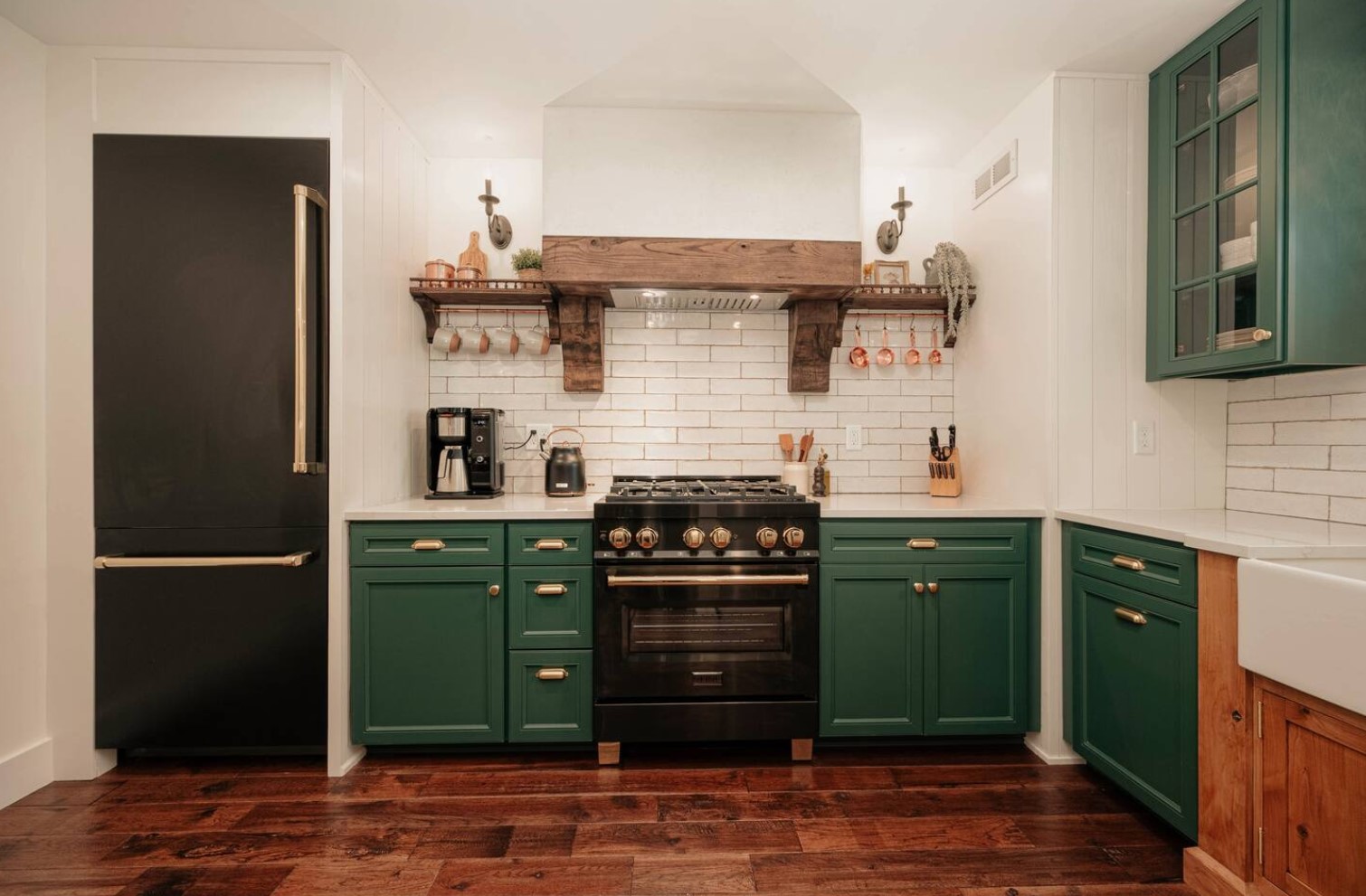 kitchen with green cabinets, black fridge and wooden floors