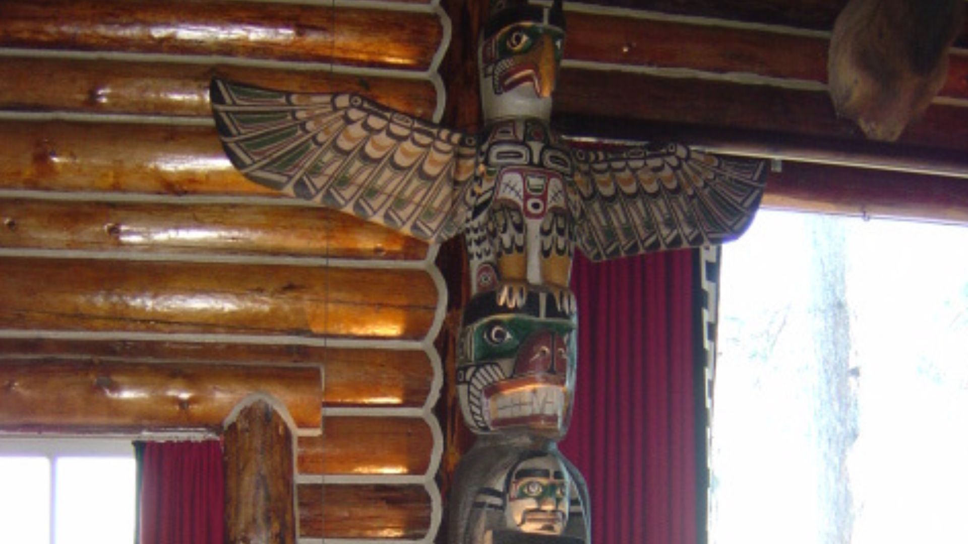 wooden totem with carved animas in the corner of the great hall