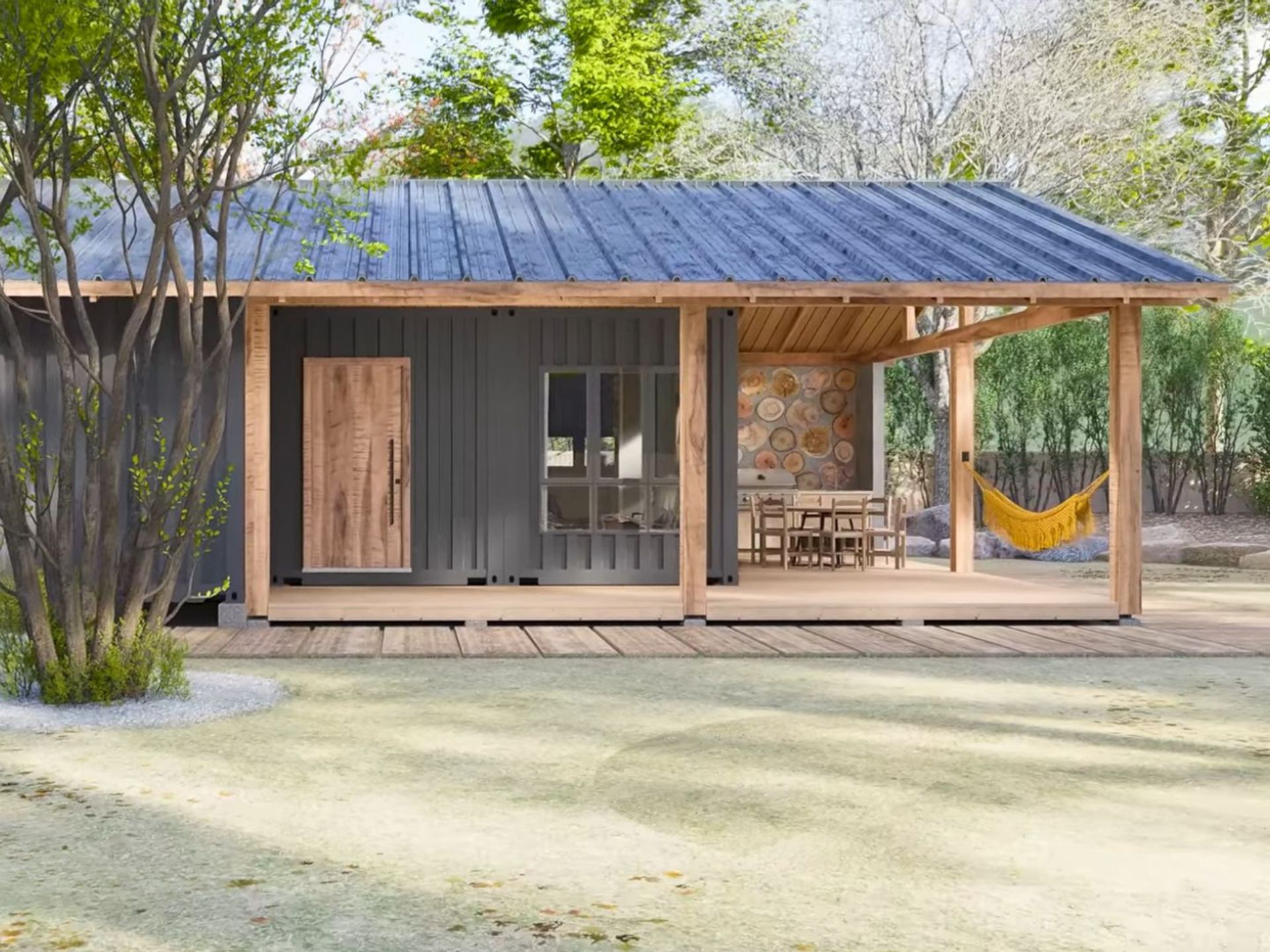 exterior of the container house with anthracite grey corrugated facade, exposed wooden beams and covered patio with a seating area next to a grill and a yellow swing net