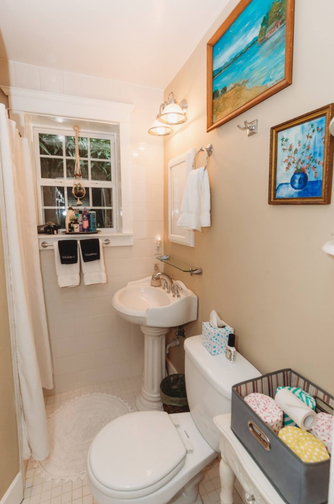 Bathroom with beige walls and two blue paintings