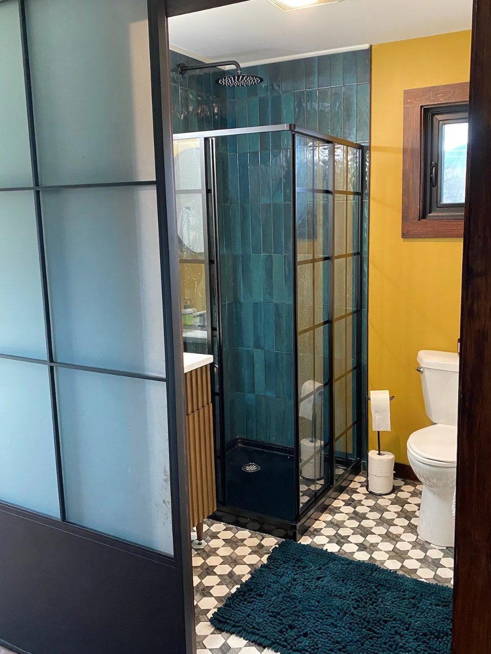 Bathroom with a yellow wall and a green shower