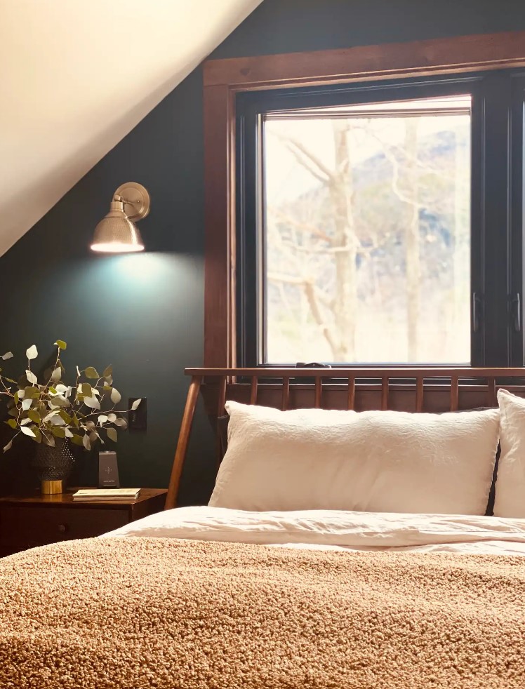 Bedroom with green wall and a window with wooden frame