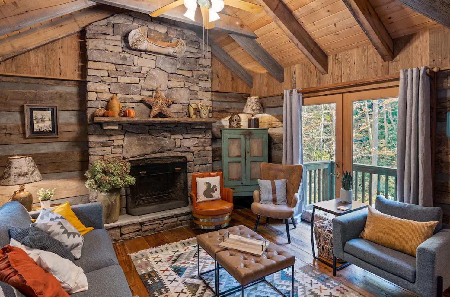 Cozy living room with stone fireplace and a colorful rug