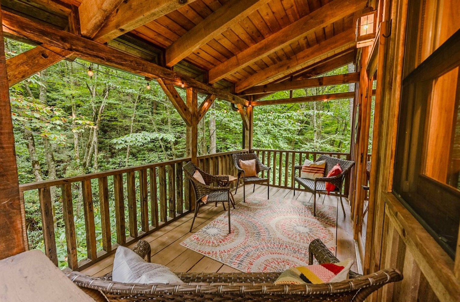 Covered deck on a cabin with a chic rug