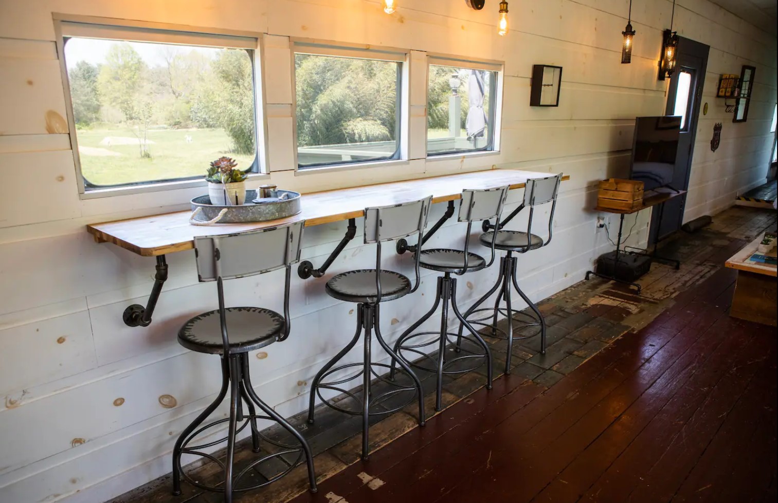 Dining area with stool chairs and a bar next to a window