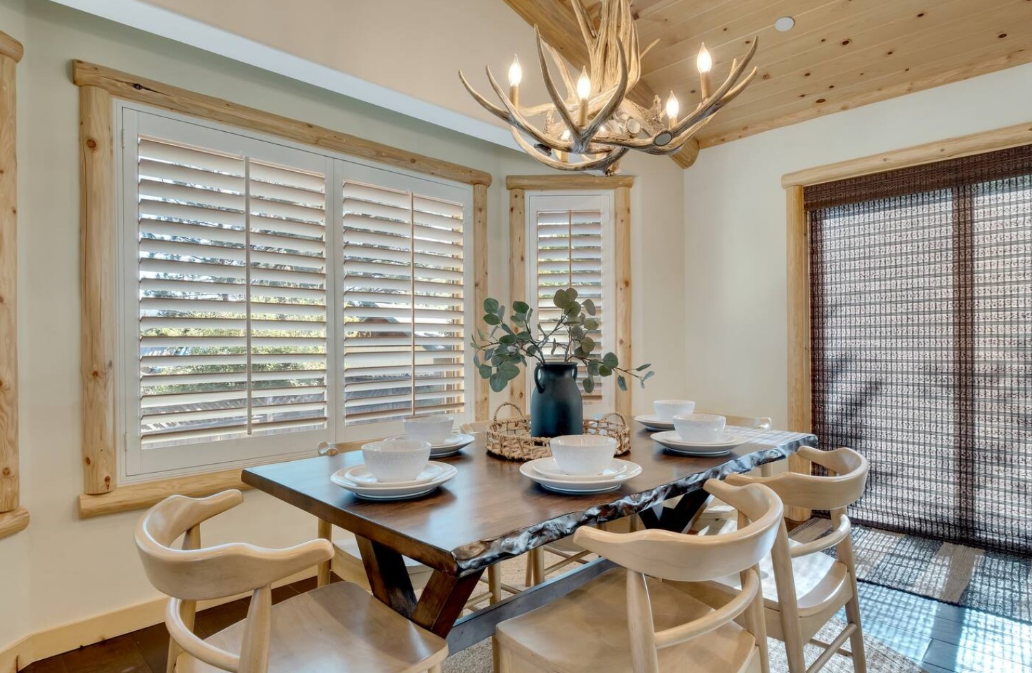 Dining room with a light fixture that looks like antlers