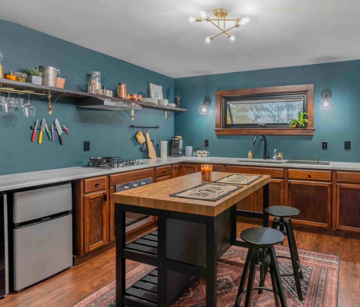 Kitchen with green walls, wooden cabinets and island