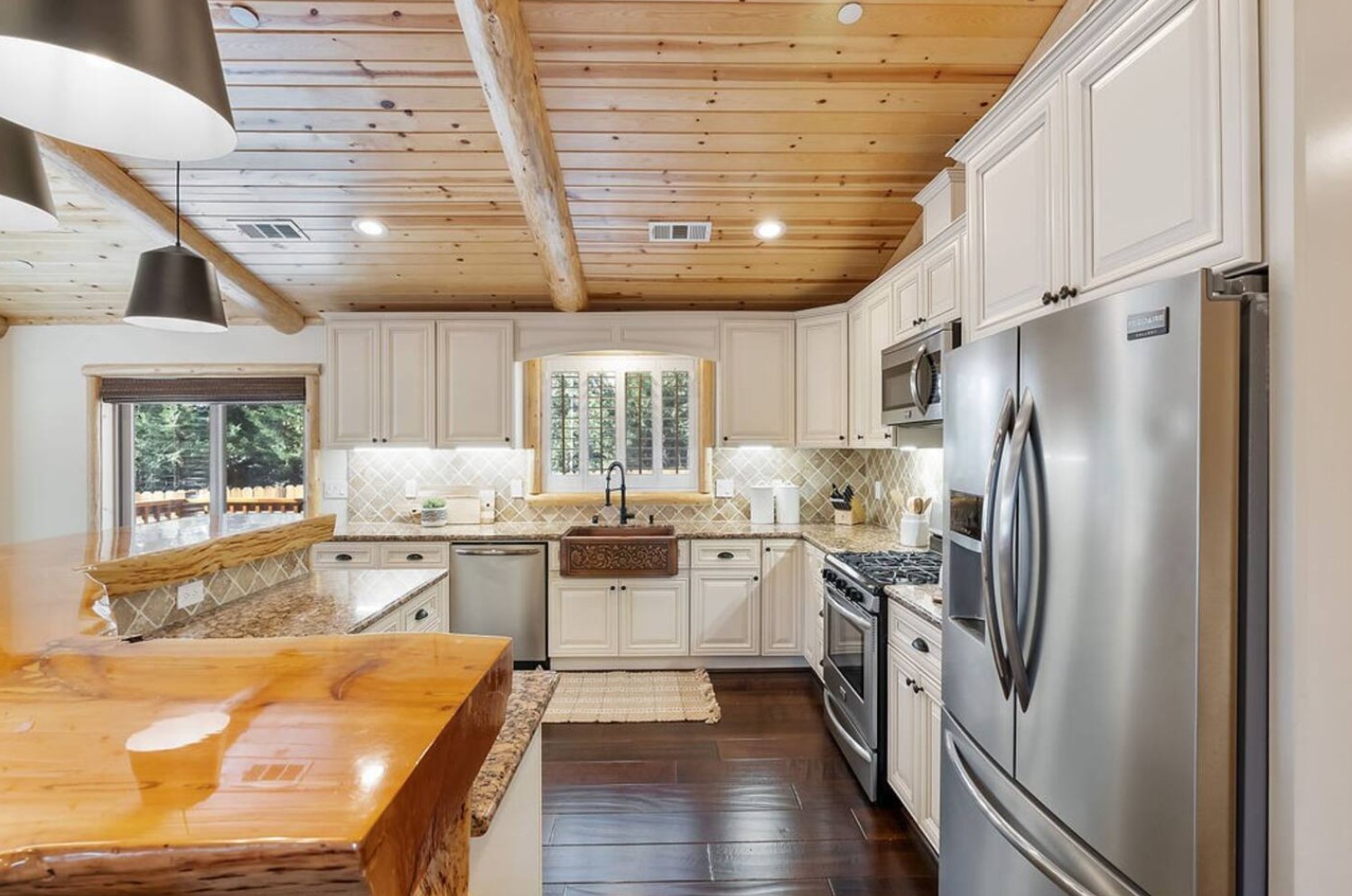 Kitchen with a wooden bar and a full-sized fridge