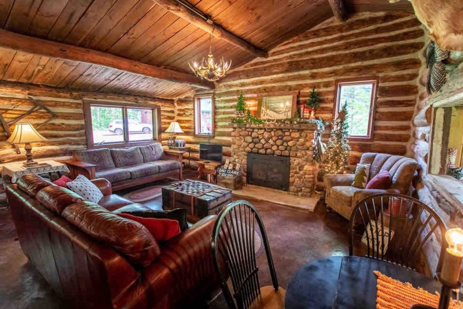 Living room with a leather couch and a stone fireplace