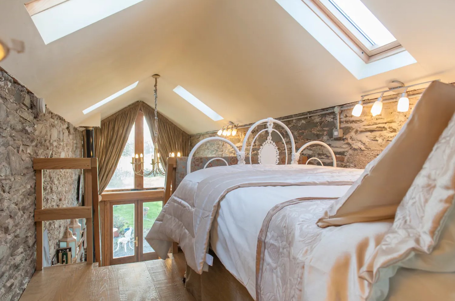 Loft bedroom with stone wall and skylights