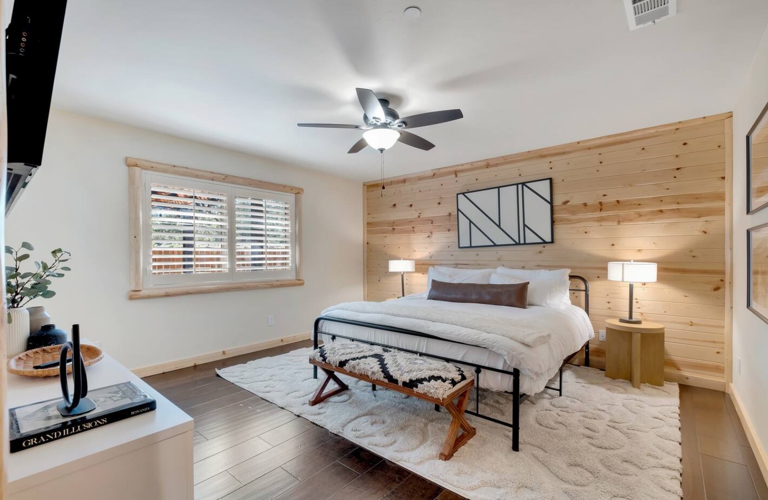 Master bedroom with wooden backsplash and black bed frame