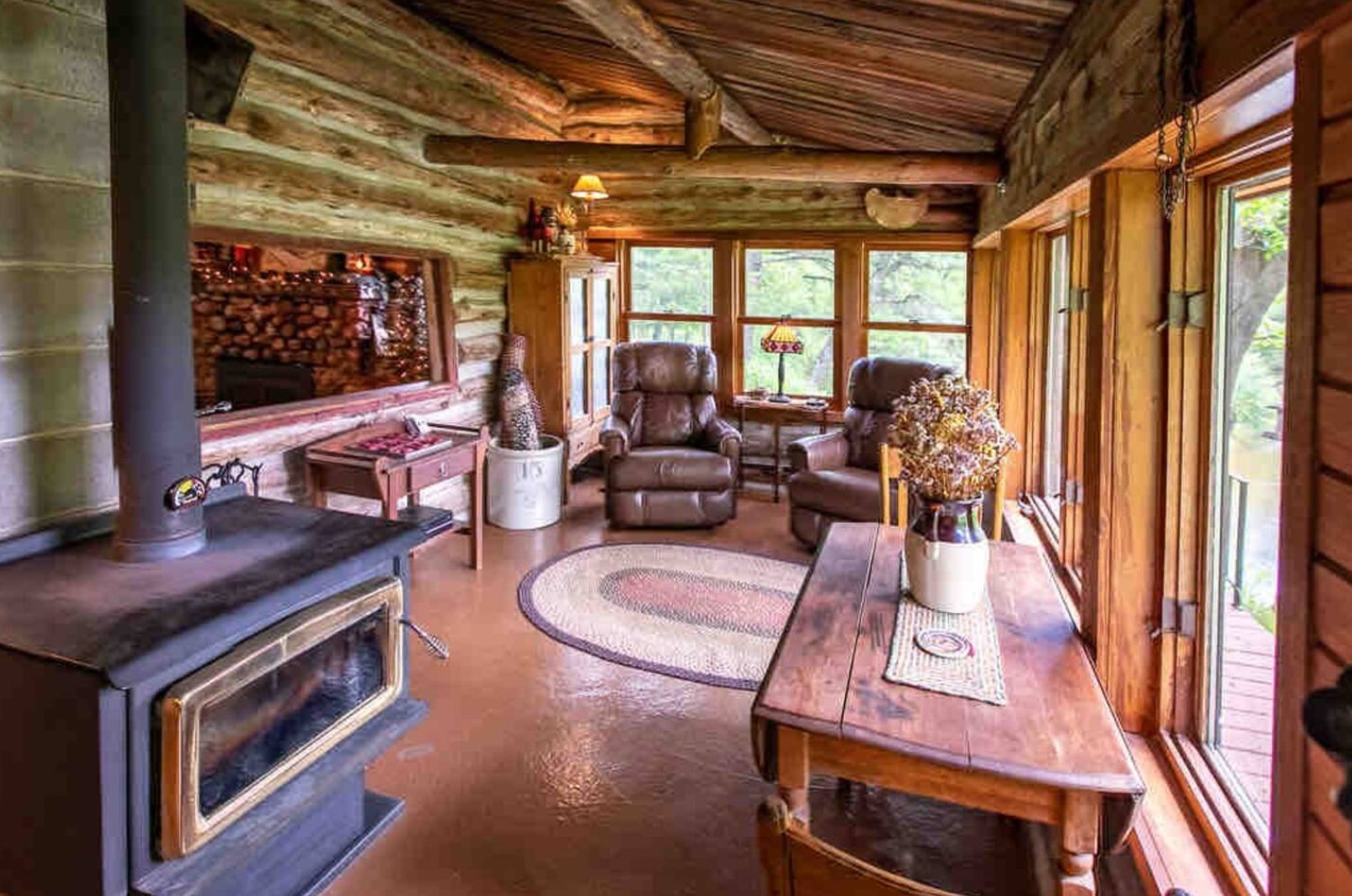 Spare room in cabin with two chairs and a fireplace