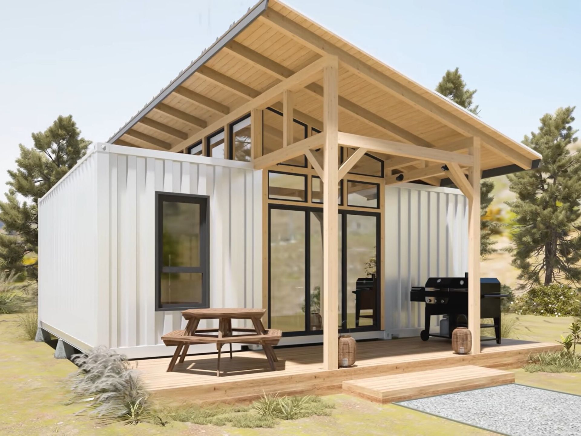 exterior of a container house with a round table and a grill in front