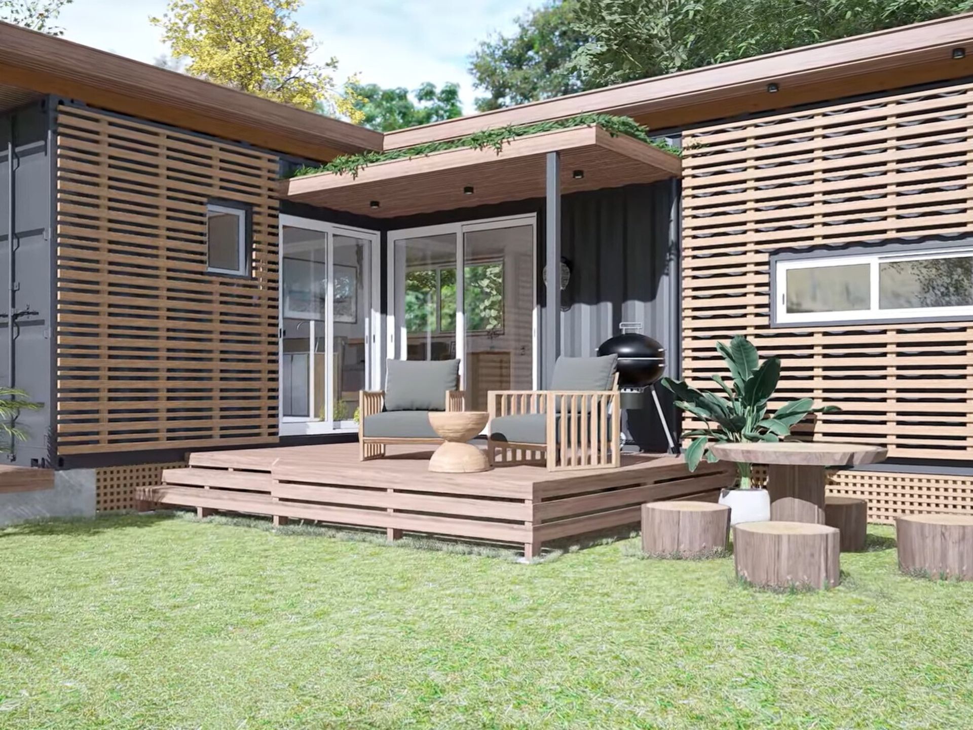 exterior of a container house with two chairs in front, and a wooden table with logs around it