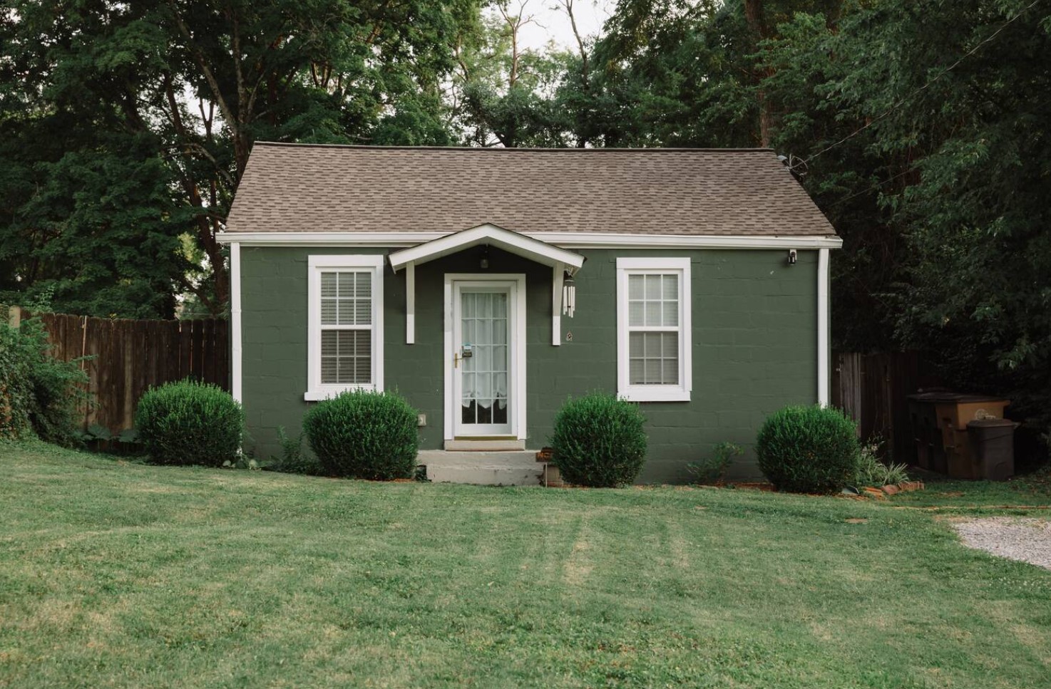 Exterior of tiny green home with brown roof