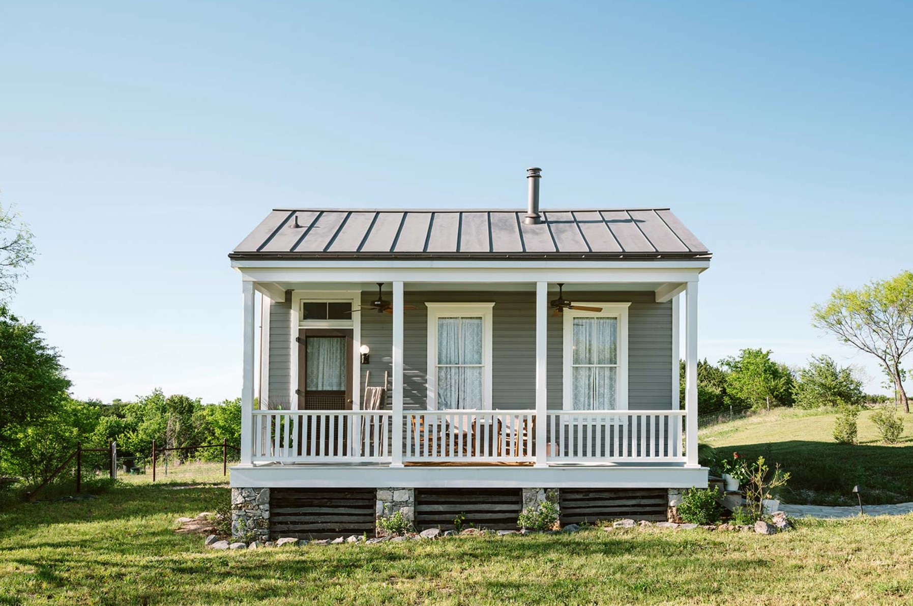 Tiny home with blue exterior and white porch