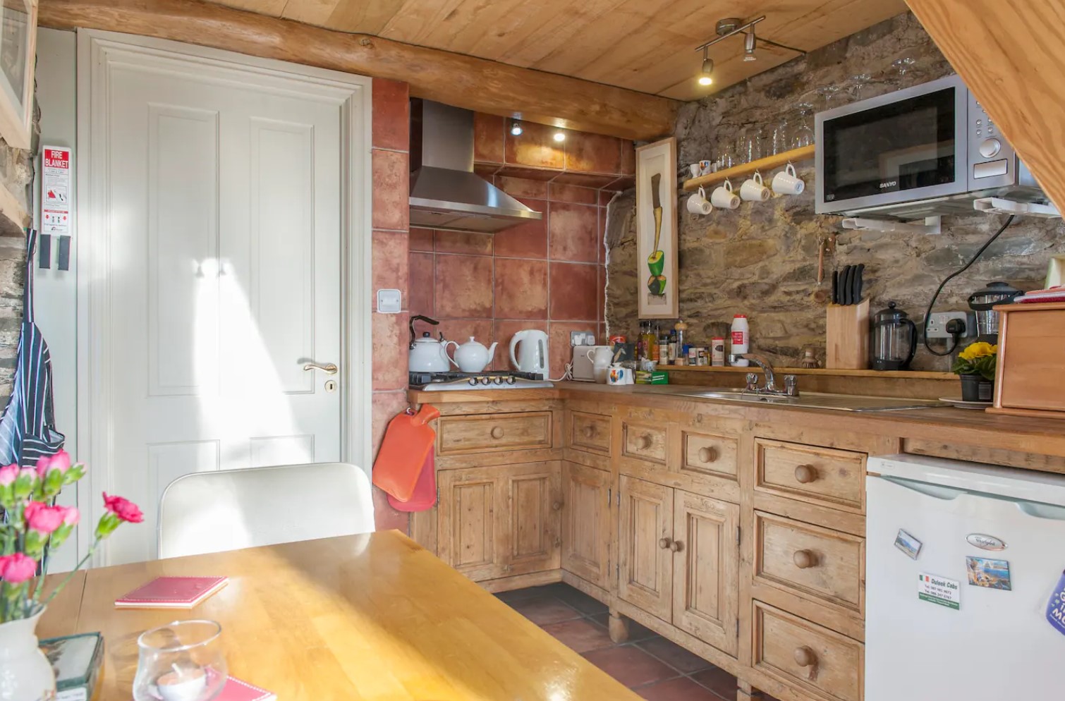 Tiny kitchen with stone wall and wooden cabinets