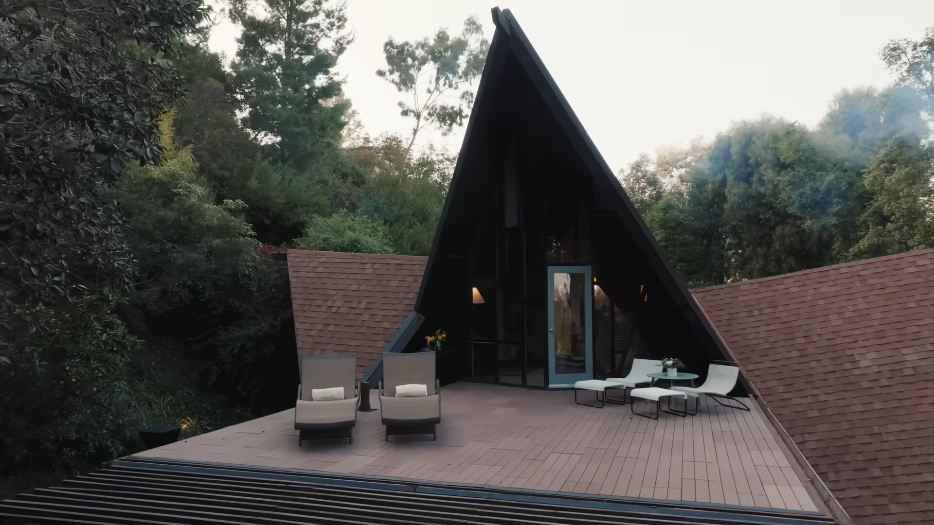 balcony of an a-frame house with two chairs and a table