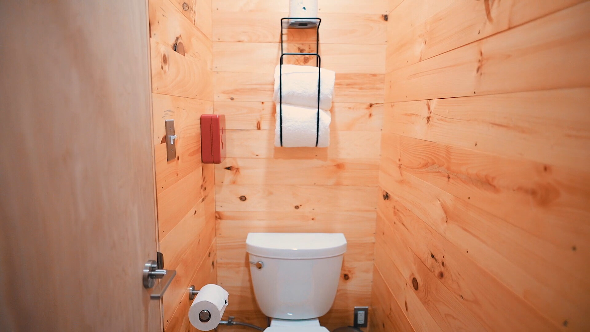 bathroom with wooden walls and white toilet