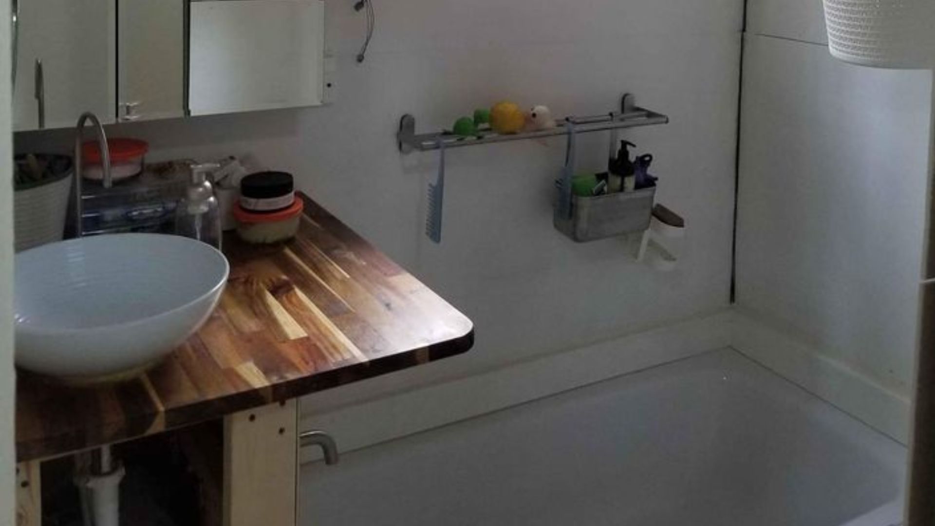 simple bathroom with a tiny sink on the left and a soak-in tub