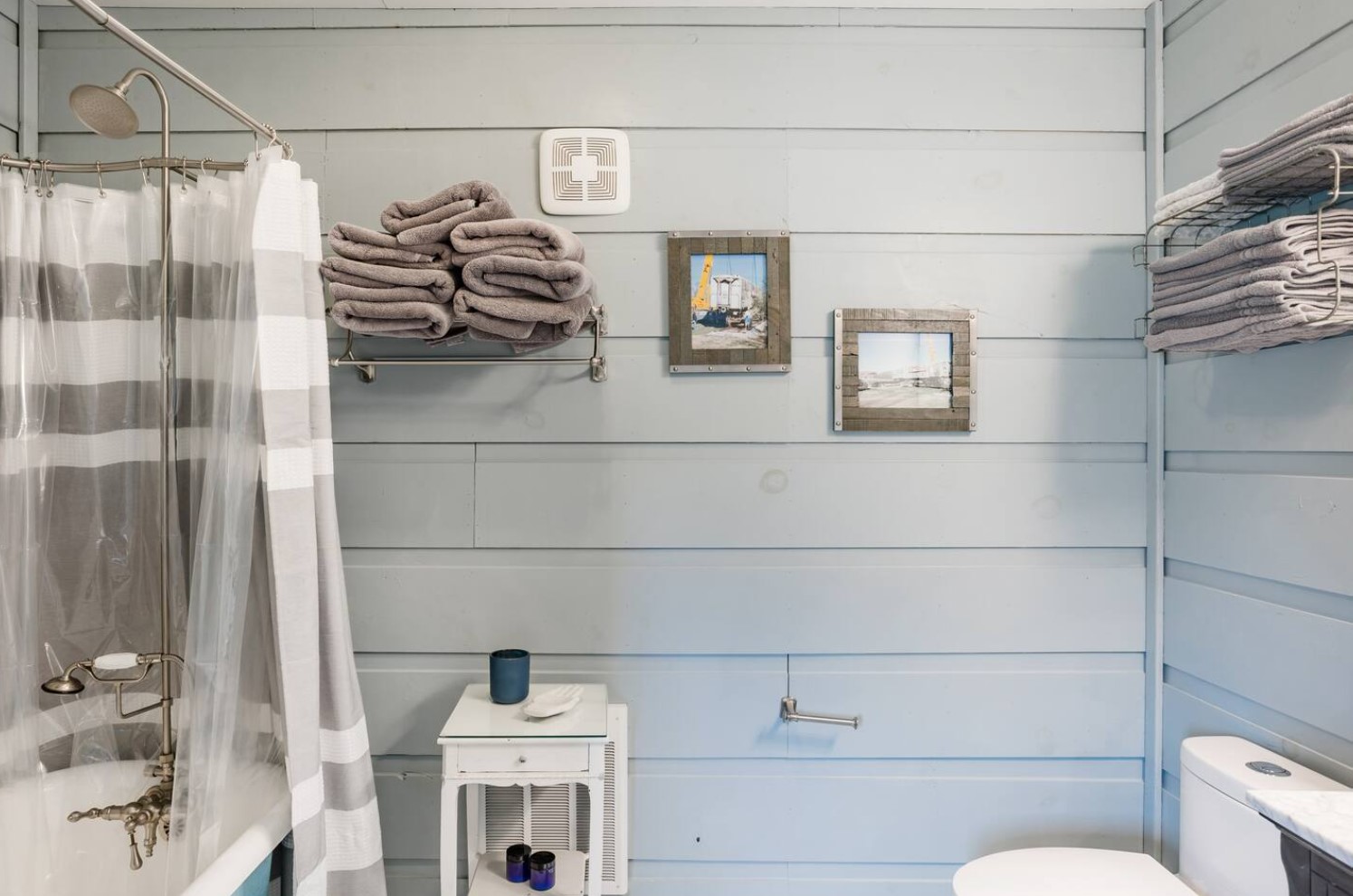 Blue bathroom with a wooden wall and decorations