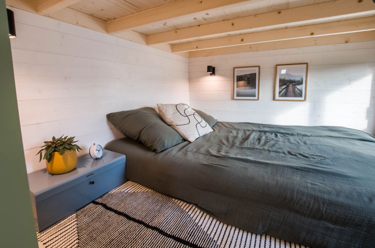 bedroom nook with a big bed and a blue bedside table