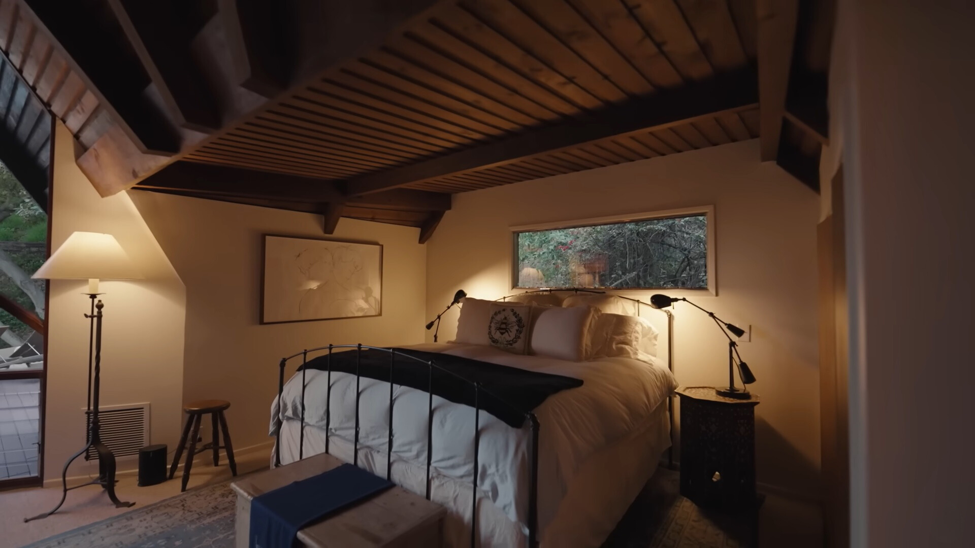 bedroom with a big bed surrounded by two lamps and a window above