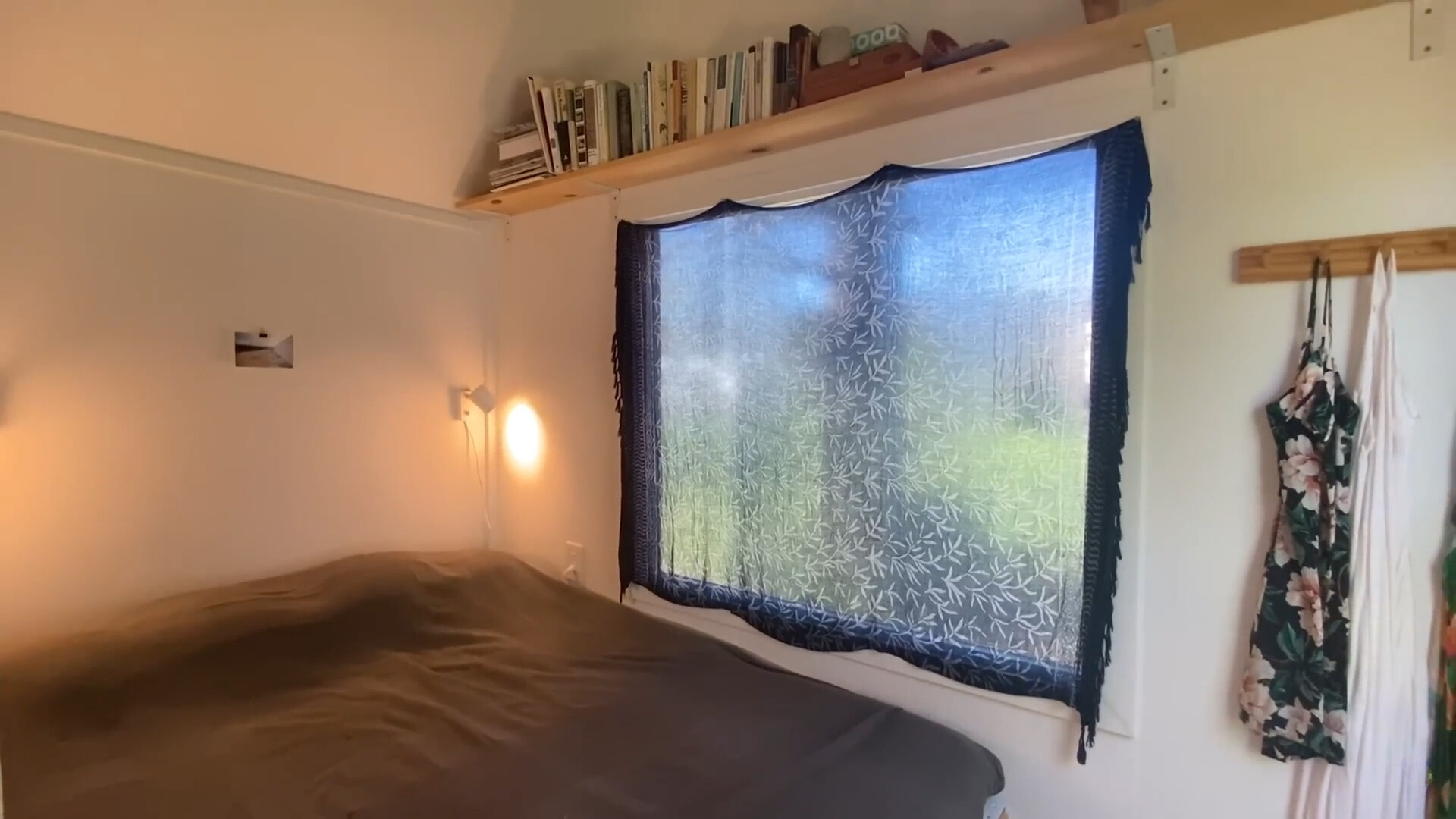 bedroom with a big bed, a big window and a shelf above the window