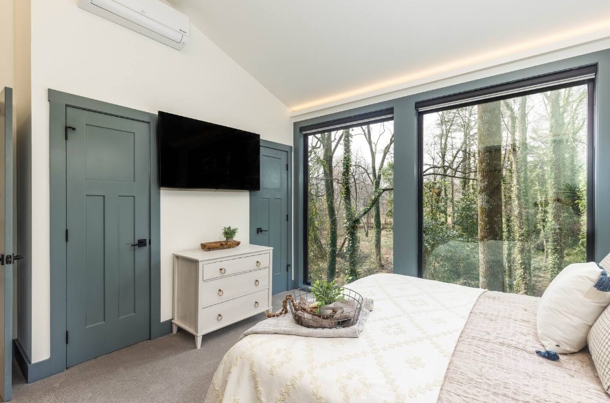 bedroom with a flat-screen tv opposite the king sized bed and floor-to-ceilings windows