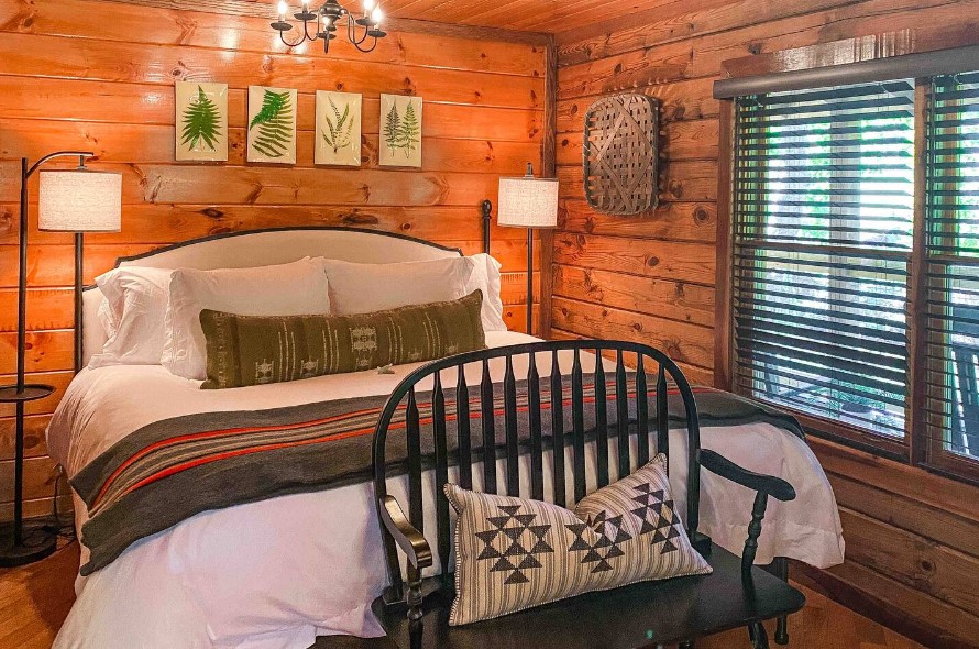 bedroom with a king-sized bed, framed plant photos above the bed, big window