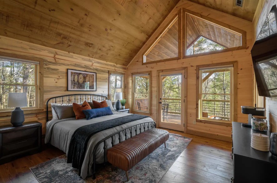 bedroom with a king-sized bed, many windows, a balcony, flat screen tv