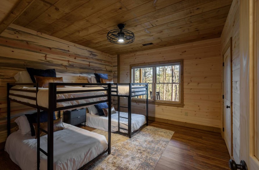 bedroom with two pairs of bunk beds and wooden walls