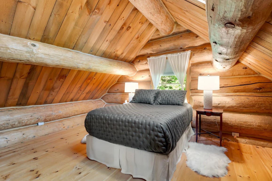 bedroom with a bed and a window behind and a bedside table