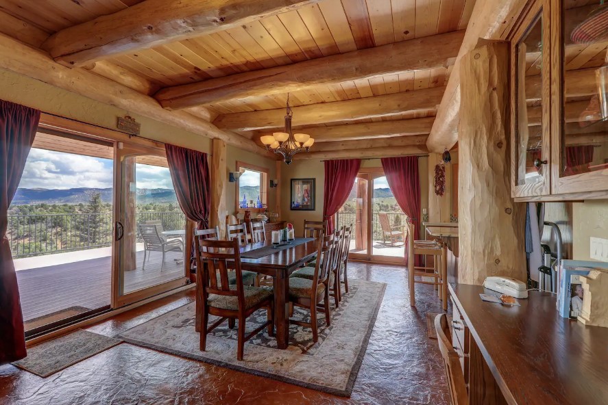 dining room with a long, brown dining tbale and glass doors