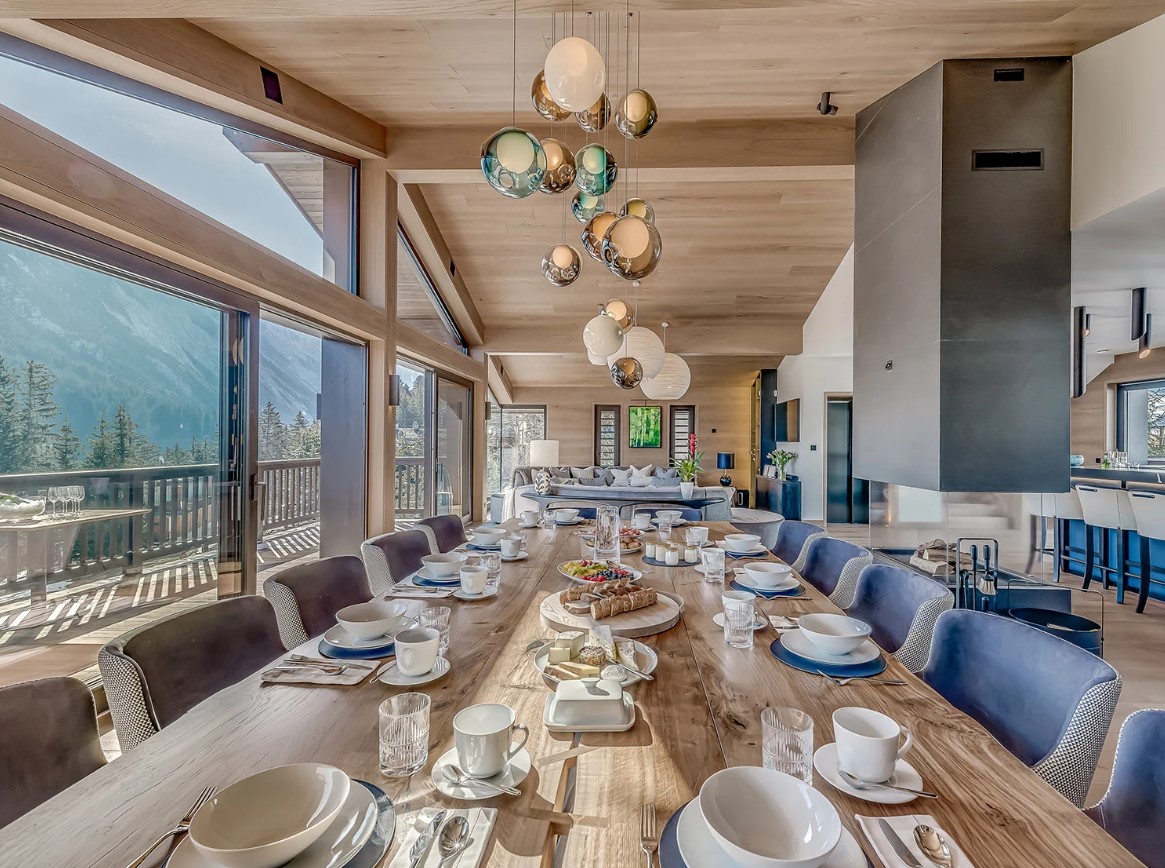 dining area with a long, brown dining table and 14 seats and beautiful, round chandelier