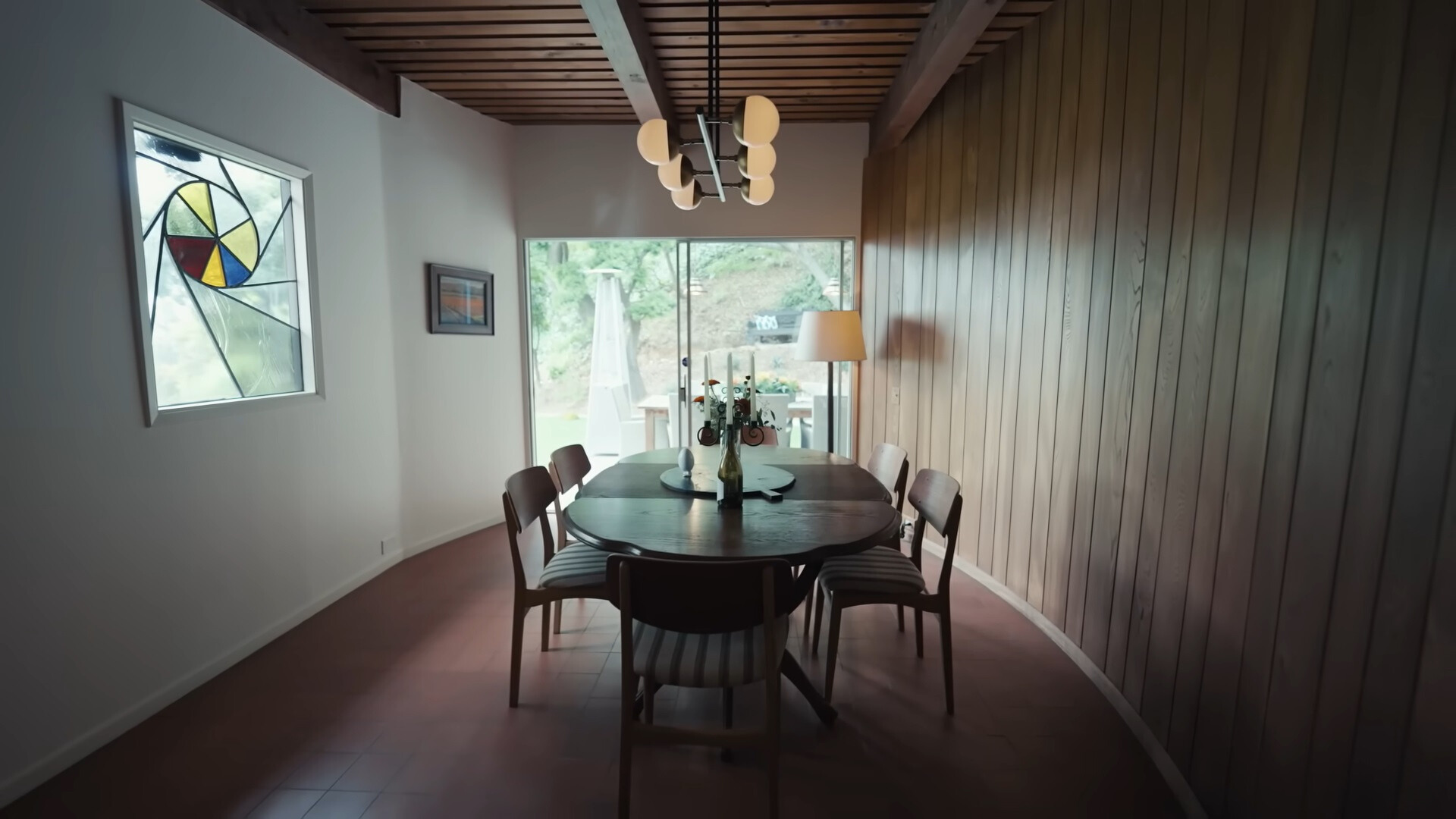 dining room with a brown table and chairs and a window with stained glass on the side