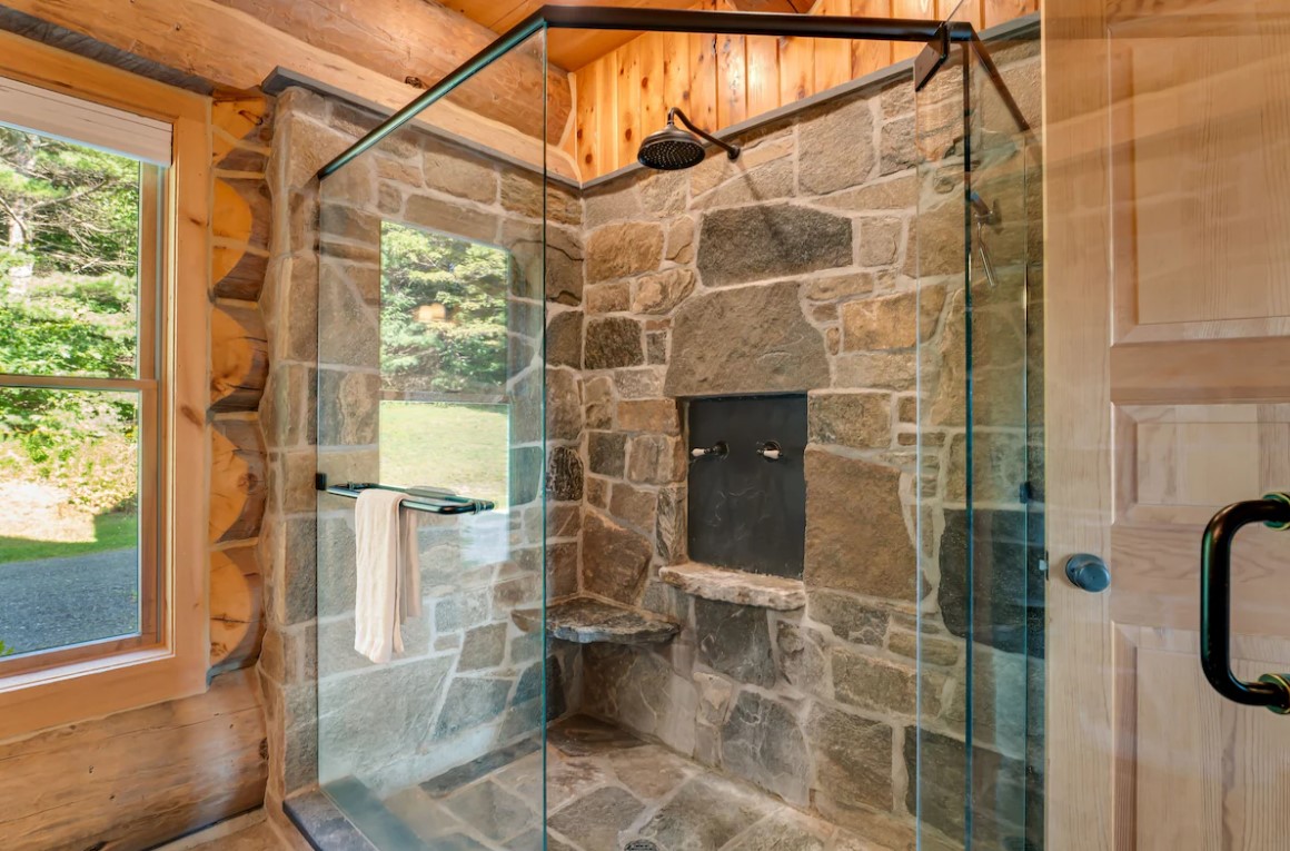 glass shower with a stone wall