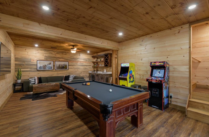 hangout room with a pool table, two arcade games, a green couch and a small brown table