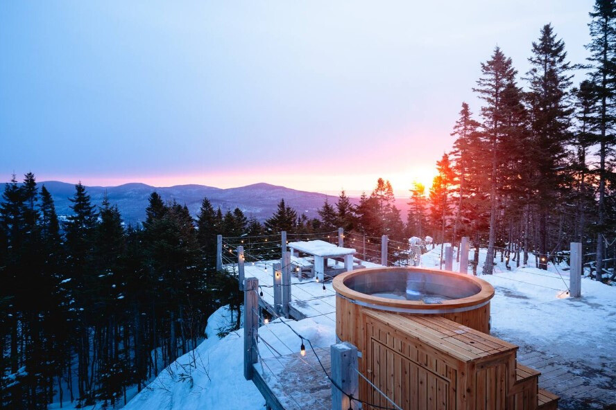 hot tub outside of a cabin and a view of the mountains