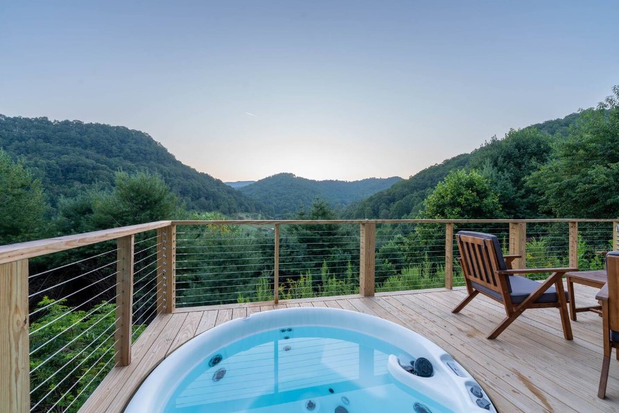 hot tub on the deck in front of the living room with a beautiful view