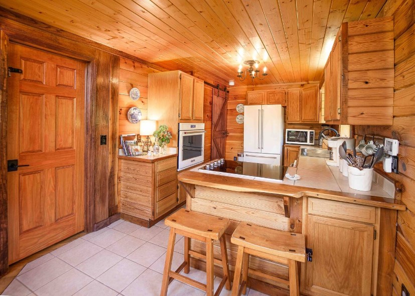 kitchen with an l-shaped countertop, brown wooden walls and brown wooden cabinets