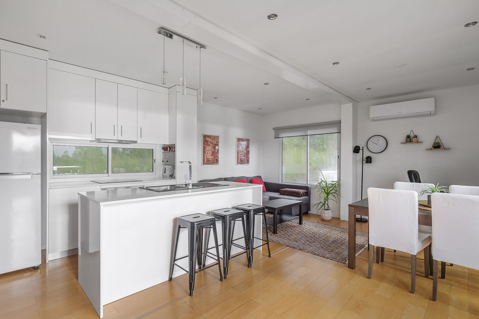 kitchen with white cabinets, white island and black bar stools