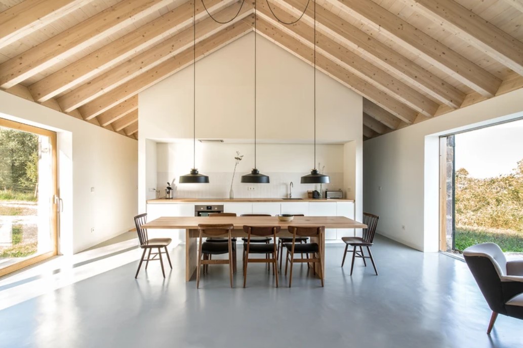 kitchen with white cabinets, brown countertop and a brown, wooden dining table and big windows on the side